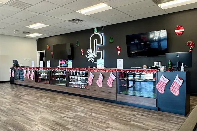 Inside Couth Cannabis, the sales counter and display cases below the lit Couth leaf sign